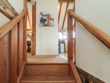 A staircase leading to a wall with a painting at The Cow Shed in Chediston near Halesworth