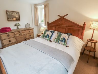 A bedroom with a bed and dresser at The Cow Shed in Chediston near Halesworth