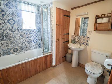 A bathroom with a shower and bathtub at The Cow Shed in Chediston near Halesworth