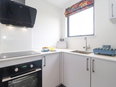 A kitchen with an oven stove range hood sink window and countertop at Bluebell Cabin in Ullswater