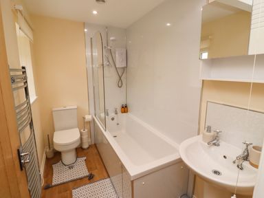 A bathroom with a bathtub shower toilet and sink at Henhill Lodge in Chathill near Seahouses