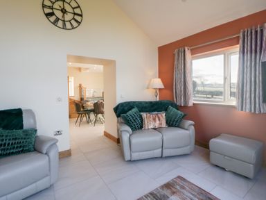A living room with a sofa and lamp at Y Stabal near Llanilar