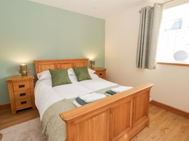 A bedroom with a bed and bedside tables at Y Stabal near Llanilar