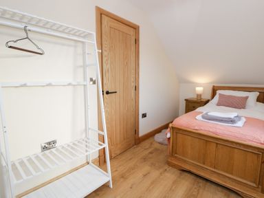A bedroom with a bed and bedside table at Y Stabal near Llanilar