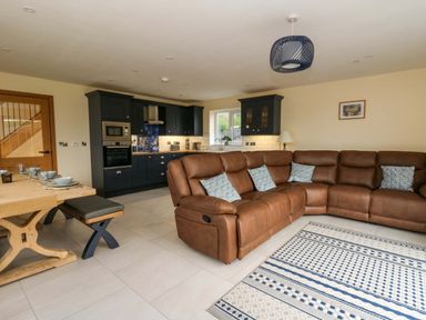 A living room with a sofa and dining table at Y Beudy near Llanilar