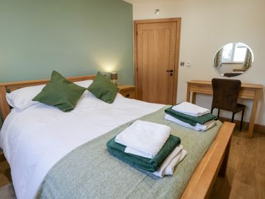 A bedroom with a bed and a mirror at Beudy near Llanilar