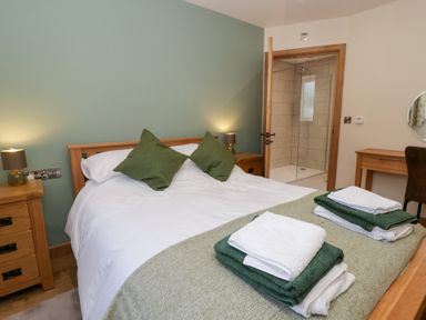 A bedroom with a double bed and en-suite shower at Beudy near Llanilar