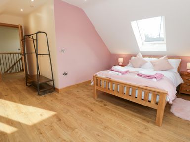 A bedroom with a bed and clothes rack at Beudy near Llanilar