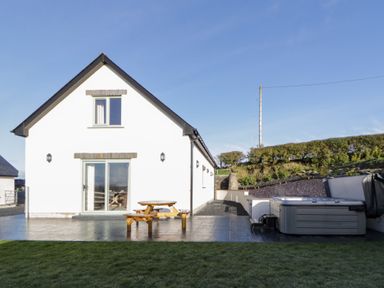 A house with a deck and hot tub at Beudy near Llanilar