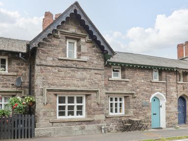 Stone houses with windows a blue door and outdoor table and chairs at Yewtree Cottage in Defynog near Sennybridge