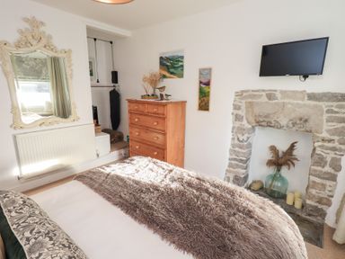 A bedroom with a mirror and wardrobe at Gosling Cottage in Kendal