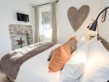 A bedroom with a bed and a TV at Gosling Cottage in Kendal