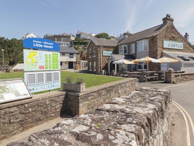 An outdoor area with a signpost and a pub at Sandy Bay Retreat Hasguard Cross near Broad Haven