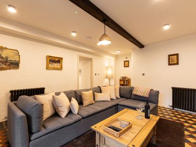 A living room with a gray sectional sofa and wooden coffee table at The Lodge in Newby Bridge