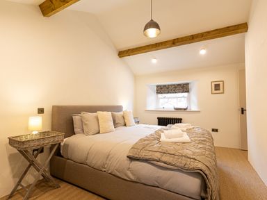 A bedroom with a bed and bedside tables with lamps at The Lodge in Newby Bridge