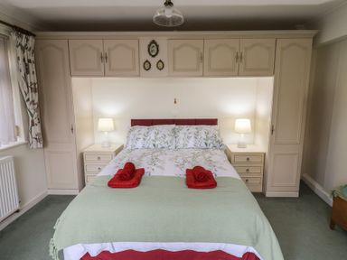 A bedroom with a double bed flanked by two bedside tables with lamps at Woodstock in Chaffcombe near Chard