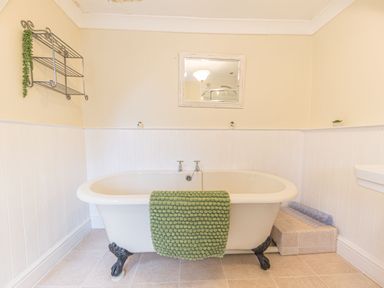 A bathroom with a clawfoot bathtub and green towel at Abbey Farm House in St Bees