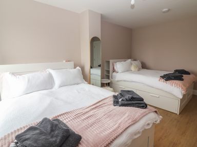 A bedroom with two beds a mirror and folded towels on each bed at 19A Lighthouse Village Fenit County Kerry