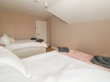 A bedroom with two single beds each with folded towels at 19A Lighthouse Village Fenit County Kerry