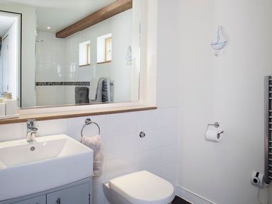 A bathroom with a sink a toilet a large mirror and a towel rack at Gull Rock 4 Rock