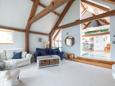 A living room with sofas and a coffee table under exposed wooden beams at Gull Rock 4 in Rock