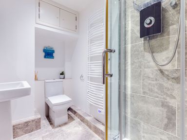A bathroom with a toilet sink shower and towel radiator at Stokes Cottage in St Minver