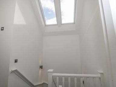 A stairway with white walls and a handrail under two skylights at Agua de Plata 16 Wakeling Island Silverlake in Dorchester