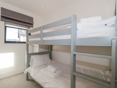 A bedroom with a gray bunk bed near a window with a closed blind at Agua de Plata 16 Wakeling Island Silverlake Dorchester