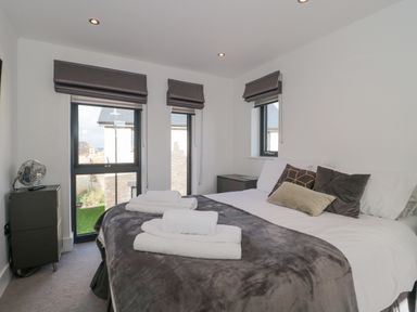 A bedroom with a bed pillows folded towels bedside tables and windows with blinds at Agua de Plata 16 Wakeling Island Silverlake Dorchester
