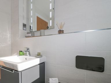 A bathroom sink with faucet toiletries and a mirror above at Agua de Plata 16 Wakeling Island Silverlake in Dorchester
