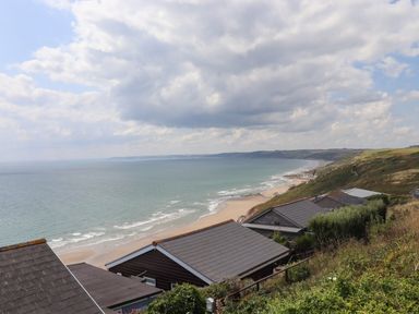 A coastal view with beach houses overlooking the sea and sandy beach at Tamar View Lodge in Millbrook