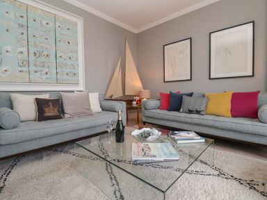 A living room with two sofas and a glass coffee table at 42 Crag Path in Aldeburgh