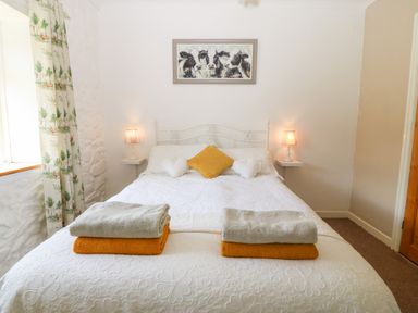 A bedroom with a white bed and folded towels on it coed y glyn bach equestrian penygroes