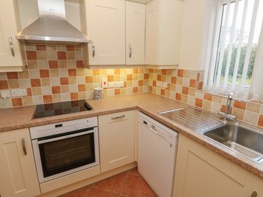 A kitchen with an oven stovetop dishwasher sink and cabinets at The Annexe Meadow Croft in Haverfordwest