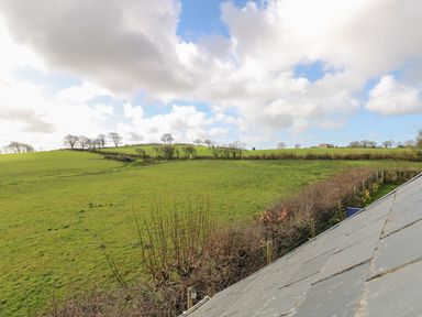 A landscape with green fields trees and a house in the distance at The Annexe Meadow Croft in Haverfordwest