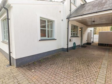 A paved driveway with white walls windows and a covered carport at 3 Strawberry Close Little Haven near Broad Haven