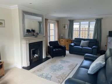 A living room with a fireplace and seating area at 3 Strawberry Close Little Haven near Broad Haven