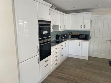 A kitchen with cabinets, oven, microwave, and kettle at 3 Strawberry Close Little Haven near Broad Haven