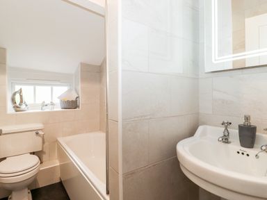 A bathroom with a toilet bathtub and sink at Holly Cottage in Grasmere