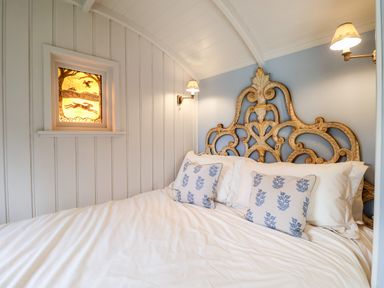 A bedroom with a carved wooden headboard and patterned pillows at Utopia in Metfield near Harleston
