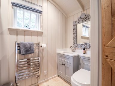 A bathroom with a window a towel rack a sink with cabinet and a mirror at Utopia in Metfield near Harleston