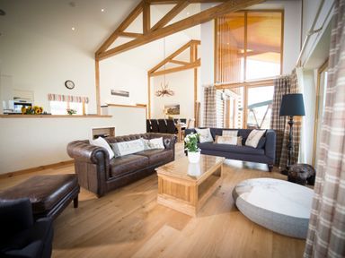 A living room with two sofas a wooden coffee table and a large round cushion at Aurae in Cawdor near Inverness