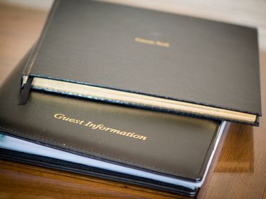 A close up of two black guest information books on a wooden surface at Aurae in Cawdor near Inverness
