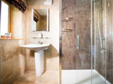 A bathroom with a pedestal sink mirror glass shower and window with patterned curtain at Aurae in Cawdor near Inverness
