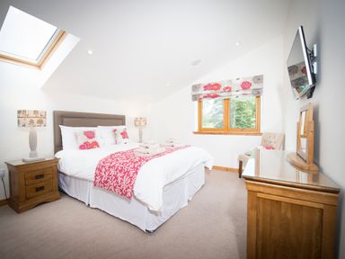 A bedroom with a double bed and bedside tables with lamps at Aurae in Cawdor near Inverness