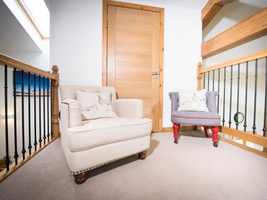 A sitting area with two armchairs and a wooden door at Aurae in Cawdor near Inverness