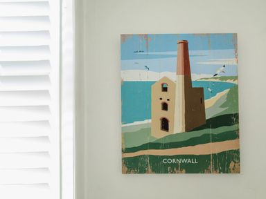 A wall with a painting of a building and coastline labeled Cornwall at 11 Belgravia Street in Penzance