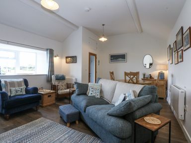 A living room with a sofa and armchair at Bwthyn Y Swnt in Moelfre