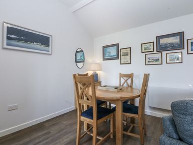 A dining room with a table and chairs at Bwthyn Y Swnt in Moelfre