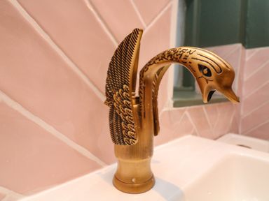 A bathroom sink faucet shaped like a bird with detailed feathers and a beak at Secret Garden 34C Clarence Street in Dartmouth